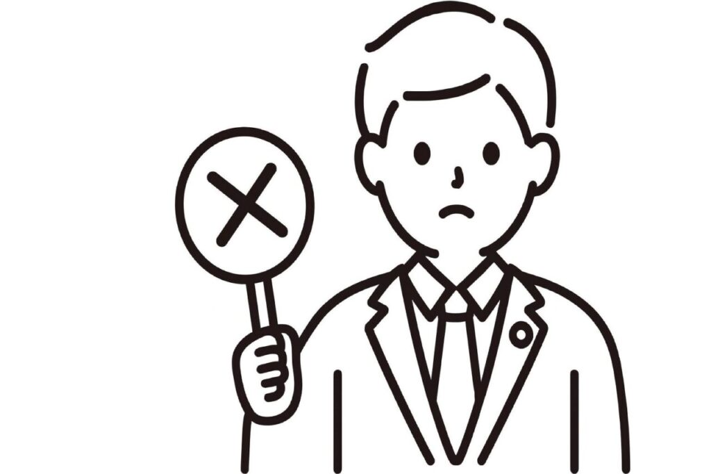スーツ姿の男性がバツ印の札を持って困った表情をしているイラスト。