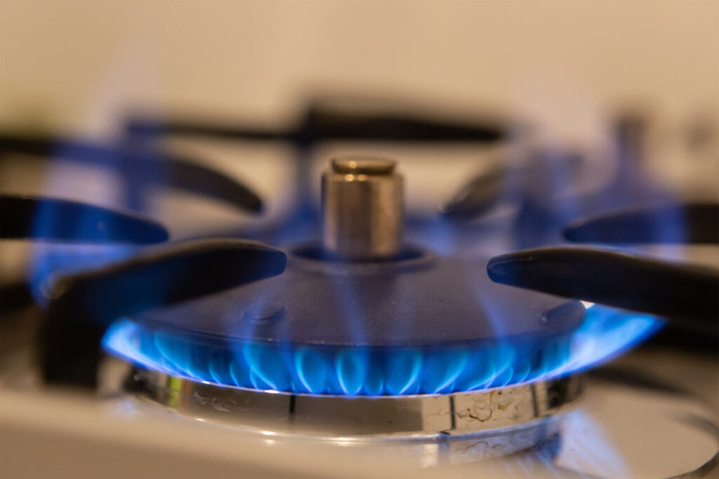 ガスコンロのバーナーで青い炎が安定して燃えている様子。燃焼状態が良好で、清潔なキッチン環境を連想させる。