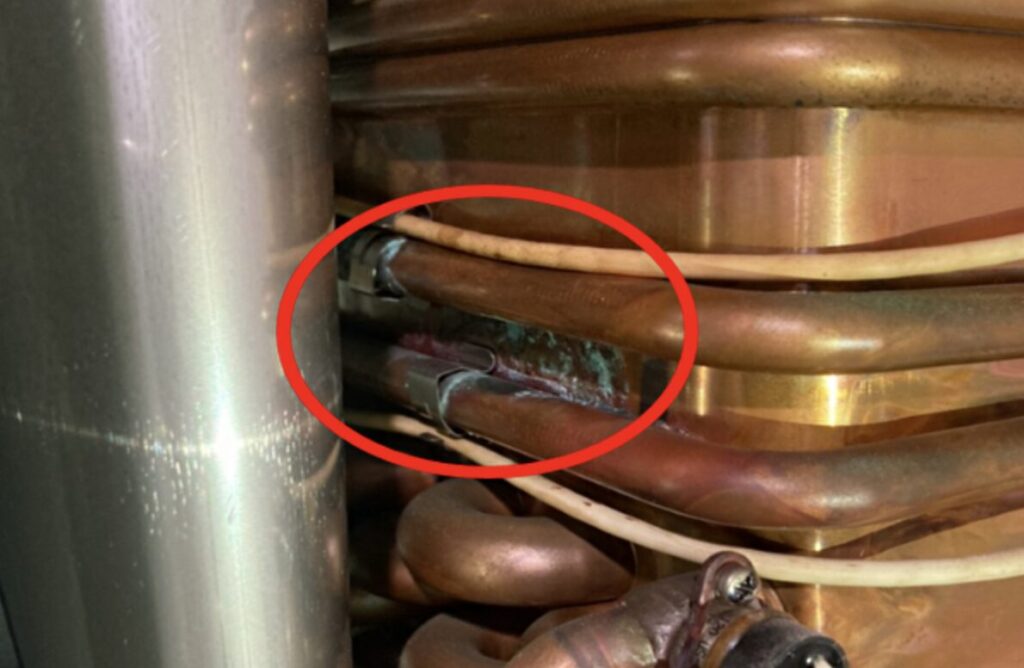 ピンホールによる水漏れを示した場所を赤い丸で囲っている