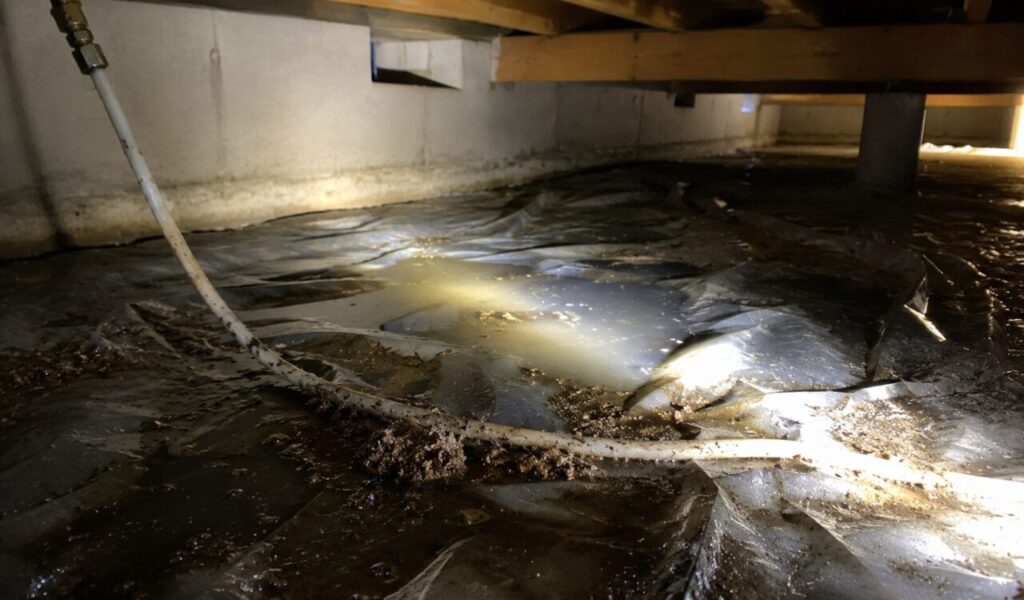 床下空間に広がった灯油漏れの様子と、汚れた配管や防湿シートが見える暗い点検空間