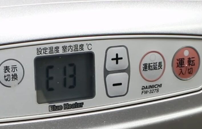 ダイニチ製ブルーヒーターの操作パネルに「E13」と表示され、運転ボタンや温度調整ボタンが確認できる状態の様子。