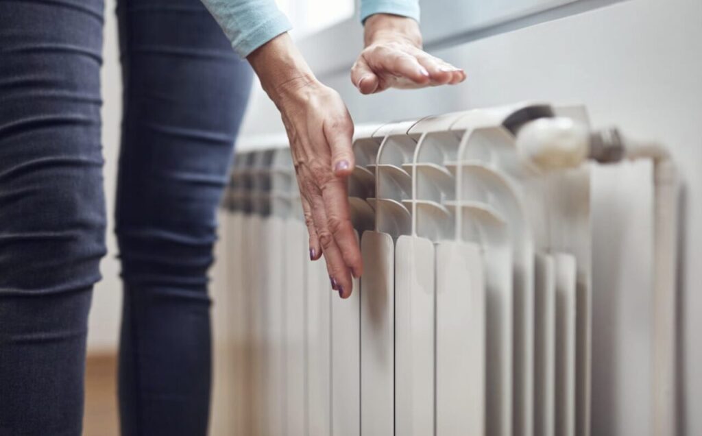 室内パネルに両手をかざして暖まり具合を確認している様子