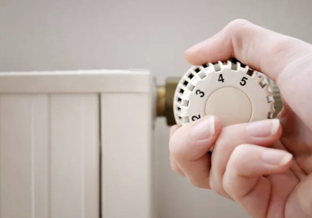 ラジエーターの温度調整ダイヤルを手で回して設定を変更している様子