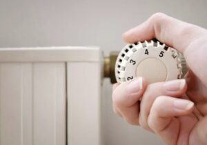 ラジエーターの温度調整ダイヤルを手で回して設定を変更している様子