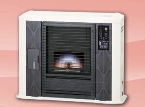 白い本体のサンポット製、床暖式石油FF式ストーブの正面。中央の燃焼窓で炎が燃えており、右側にはデジタル表示パネル、左側には不凍液の残量確認窓がある暖房機器。