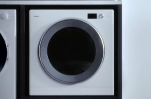 白いドラム式乾燥機の正面が中央に配置されたシンプルなランドリースペースのクローズアップビュー