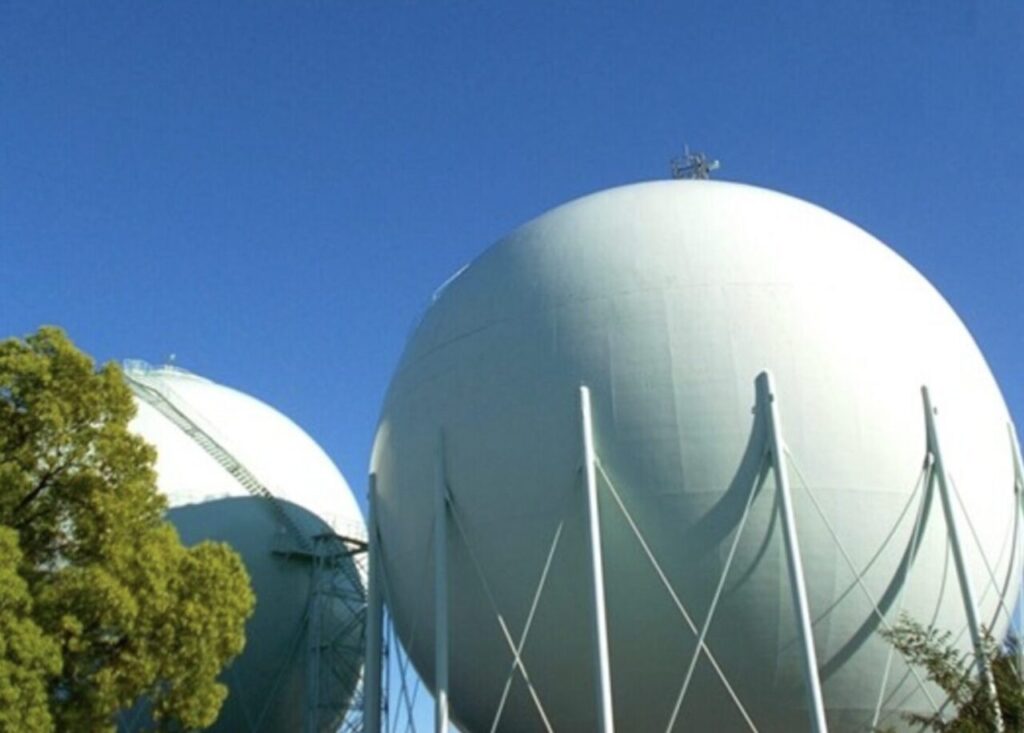 球形の大型ガスホルダーが青空の下に並ぶガス貯蔵施設の風景